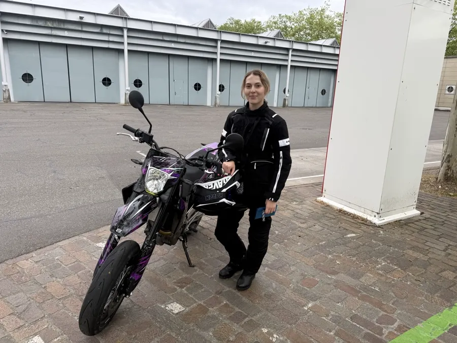 Fahrschülerin neben ihrem Motorrad nach der Fahrstunde